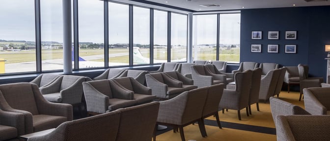 The seating area in the Northern Lights Executive Lounge at Aberdeen International Airport offers comfortable chairs with expansive runway views.