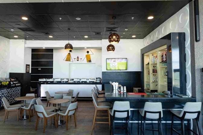 The Adinkra Lounge at Kotoka International Airport features a bar with counter seating and a buffet area with tables.