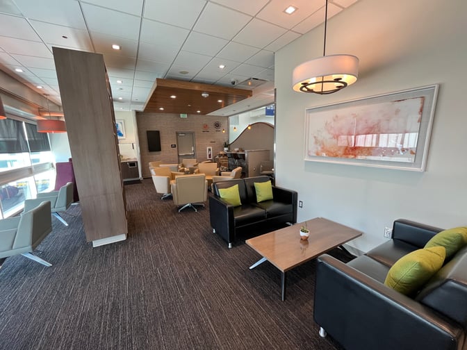 The Aspire Lounge at Ontario International Airport features a seating area with armchairs and sofas, providing a comfortable space for travelers.