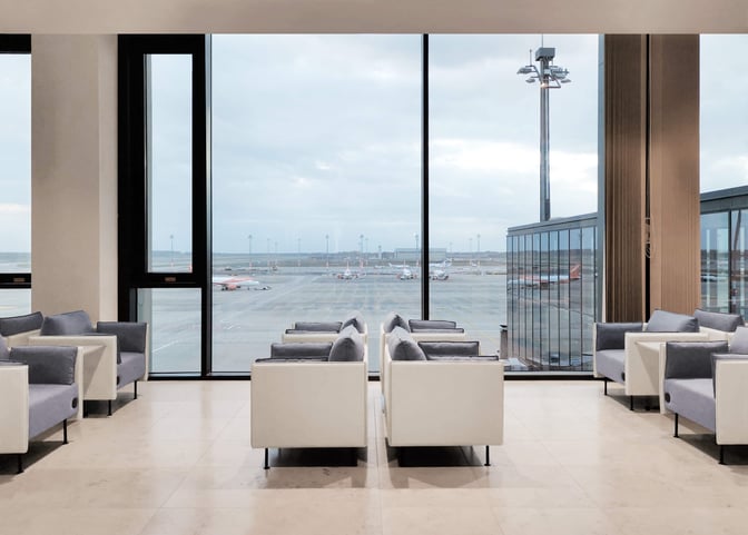 Seating area at Lounge Tempelhof in Berlin Brandenburg International Airport offers comfortable chairs with expansive views of the airport runway.