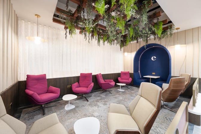 The Essence Lounge at Bristol Airport features comfortable seating with individual tables and a semi-private booth area for travelers.