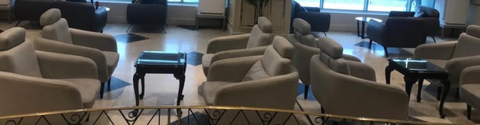 The seating area in the CAC Lounge at Cairo International Airport features comfortable chairs and small tables, offering a relaxing space for travelers.