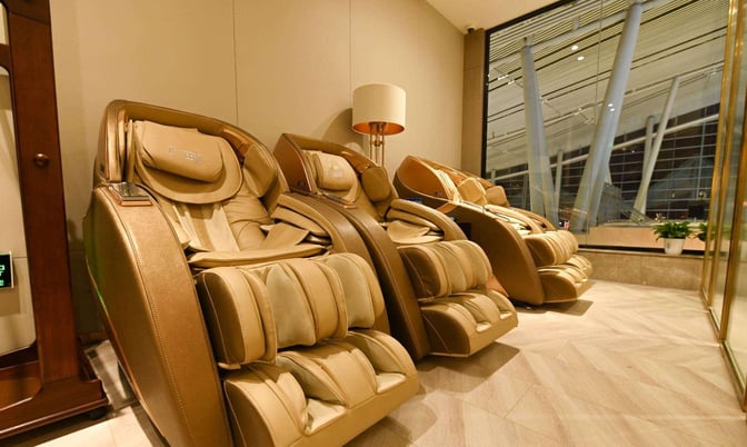 Massage chairs in the China Southern First/Business Class Lounge at Changsha Airport offer relaxation with views of the terminal.