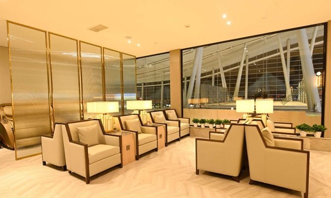 Seating area in China Southern First/Business Class Lounge at Changsha Airport features armchairs, side tables, and views of the terminal.