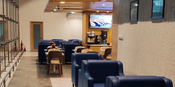 The Aviserv Lounge at Chhatrapati Shivaji International Airport features comfortable seating, a coffee machine, and a television for passenger relaxation.