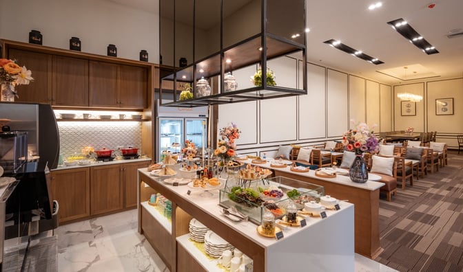 The Coral Executive Lounge at Chiang Mai International Airport features a self-serve buffet with a variety of snacks and seating areas.