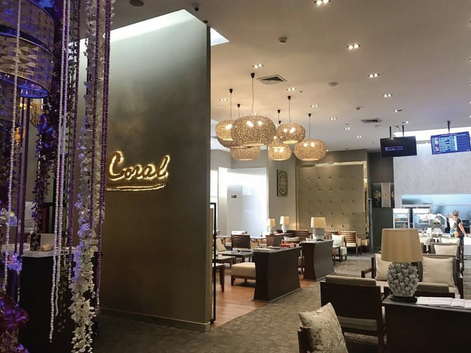 The Coral Executive Lounge at Chiang Mai International Airport features comfortable seating areas and a self-serve refreshment station for travelers.