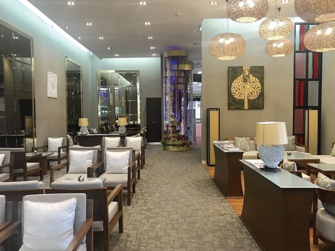 The Coral Executive Lounge at Chiang Mai International Airport features comfortable seating with tables and lamps, providing a relaxing waiting area.