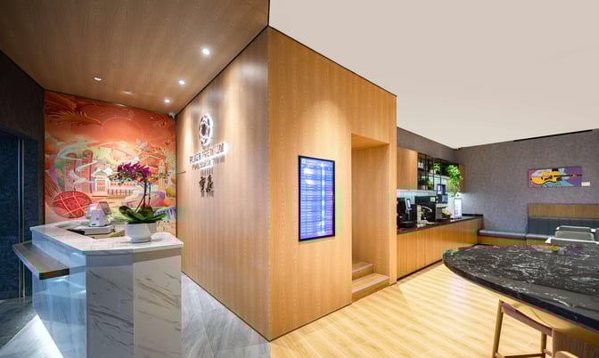 The Plaza Premium Lounge at Chongqing Jiangbei International Airport features a reception desk and a seating area with a coffee station.