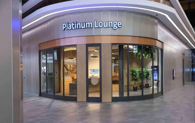 The entrance to the Platinum Lounge at Cukurova International Airport features glass doors and visible interior greenery.