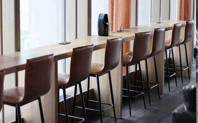 Counter seating at the Celebi COV Domestic Lounge offers high chairs and charging stations, providing a functional space for travelers.