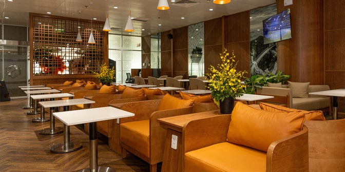 The seating area in SH Premium Lounge Da Nang features individual chairs with side tables, providing a comfortable space for travelers.