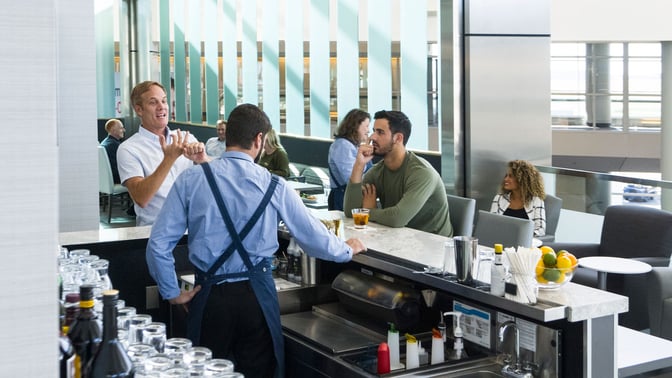 The Club DFW bar at Dallas-Fort Worth International Airport offers a variety of beverages with seating for socializing and relaxation.