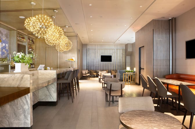 The Plaza Premium Lounge at Dallas-Fort Worth International Airport features a bar with seating and a variety of dining tables.