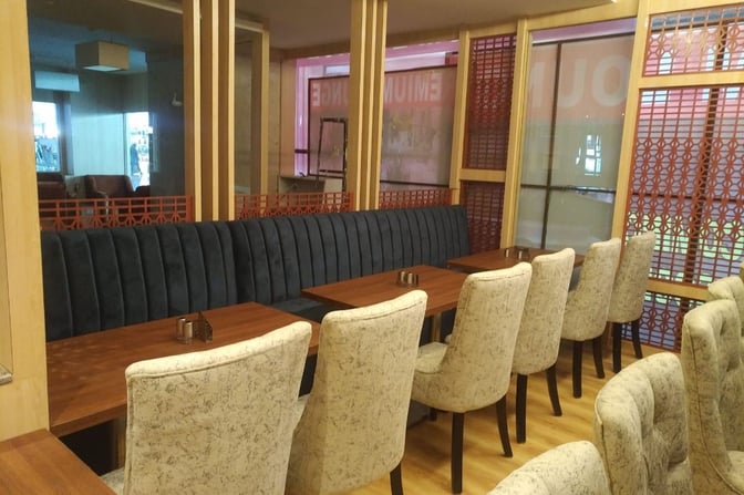 Booth seating at the Primus Lounge in Devi Ahilyabai Holkar Airport offers semi-private dining with individual tables and cushioned chairs.