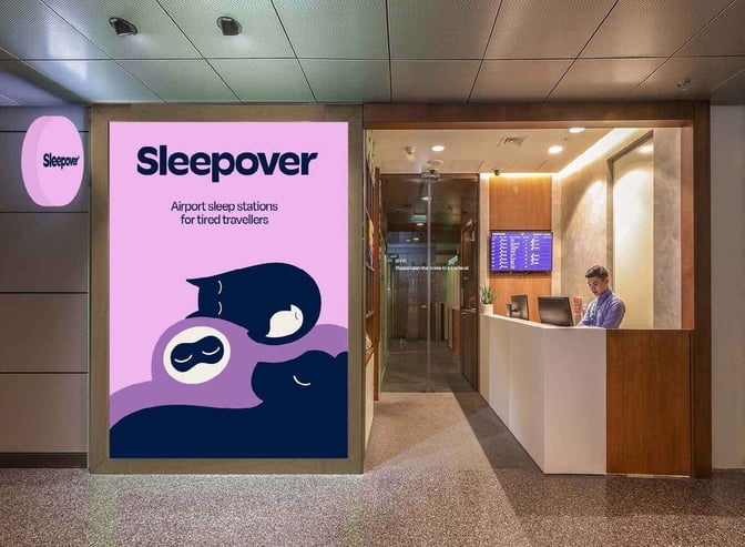 The Sleepover South Node entrance at Doha Hamad International Airport features a reception desk and flight information display.