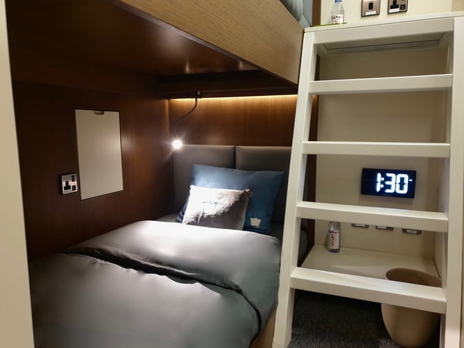 The sleep 'n fly YAWN Bunk Cabin at Doha Hamad International Airport features a bed, reading light, and digital clock for travelers.