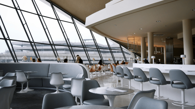 The seating area in the Miracle Lounge at Don Mueang International Airport features tables and chairs with large windows offering airport views.