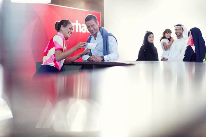 The reception area of marhaba Lounge at Dubai International Airport Terminal 2 features staff assisting travelers with check-in and inquiries.