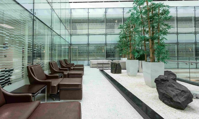 The Ahlan Lounge at Gate A1 in Dubai International Airport features a seating area with lounge chairs and decorative plants.