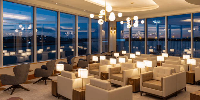 The seating area in Plaza Premium Lounge at Edinburgh Airport features armchairs with individual lamps and views of the tarmac.