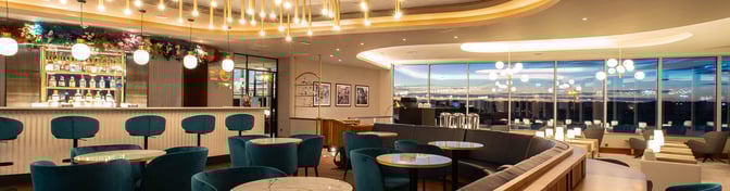 The Plaza Premium Lounge at Edinburgh Airport features a bar with a variety of spirits and ample seating for travelers.