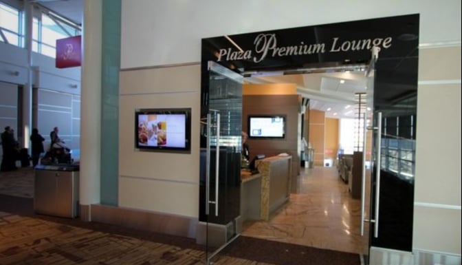The entrance to the Plaza Premium Lounge at Edmonton International Airport features glass doors and a reception desk visible inside.