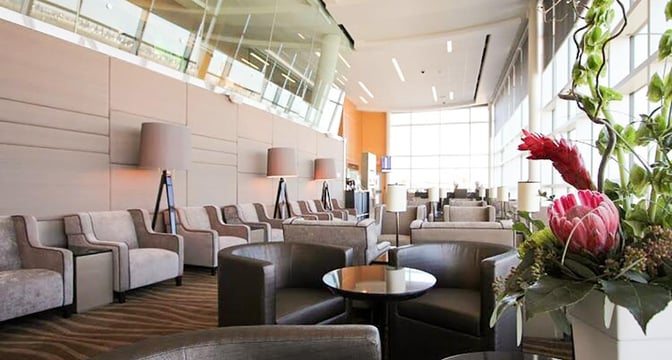The seating area in Plaza Premium Lounge at Edmonton International Airport features comfortable chairs and tables with ample natural light.