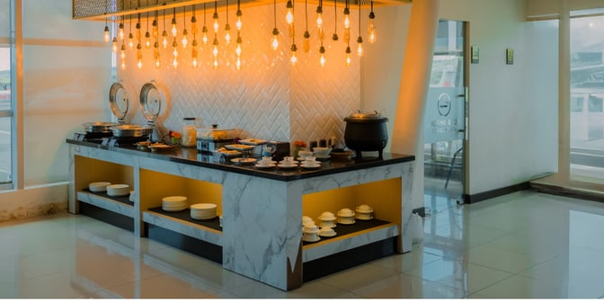 The Concordia Lounge at El Tari Airport features a self-serve food station with hot dishes, snacks, and ample dishware.