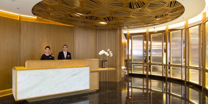 The reception area of Plaza Premium Lounge at Rio de Janeiro–Galeão Airport features a staffed desk and decorative wooden paneling.