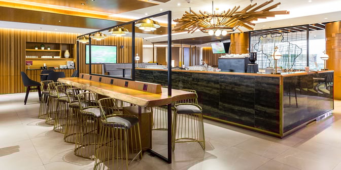 The Plaza Premium Lounge at Rio de Janeiro–Galeão International Airport features a bar area with high-top seating and charging stations.