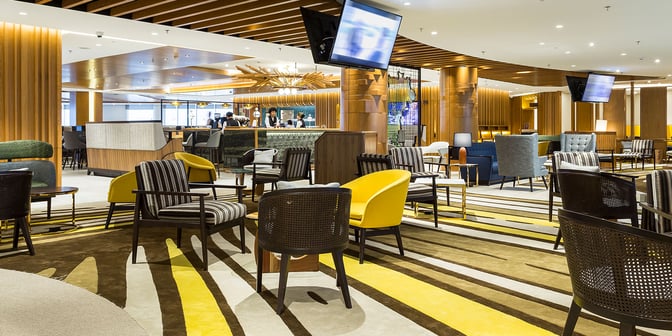 The Plaza Premium Lounge at Rio de Janeiro–Galeão International Airport features a spacious seating area with various chairs and a visible bar.