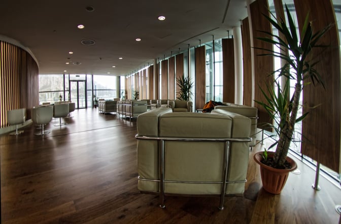 The Calpe Lounge at Gibraltar International Airport features comfortable seating with views of the runway through large windows.