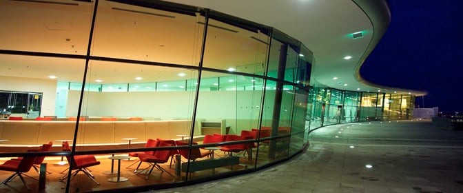 The VIP Lounge at Graz Airport features a spacious seating area with tables and chairs, visible through large glass windows.