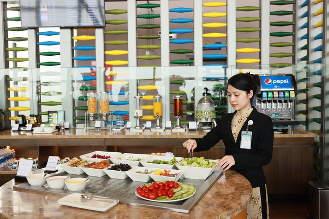 The SH Premium Lounge in Hanoi features a self-serve food station with a variety of salads and beverages available.