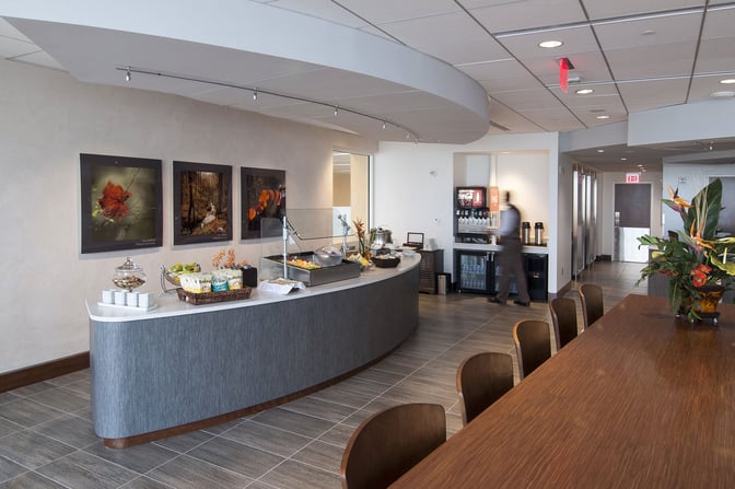 Self-serve food station at The Club ATL offers snacks and beverages, with seating nearby for dining convenience.