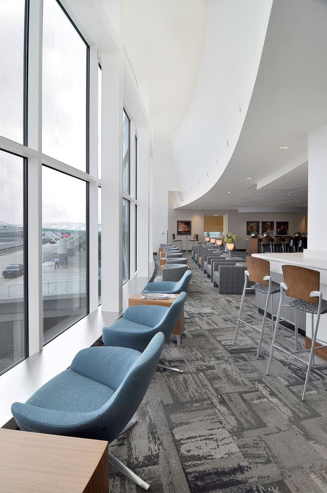 The Club ATL lounge at Hartsfield–Jackson Atlanta International Airport features seating with airport views and a bar area for refreshments.