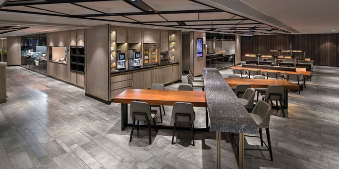 The Plaza Premium Lounge near Gate 1 at Hong Kong International Airport features a spacious seating area with tables and chairs.