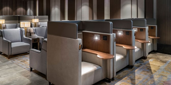 Semi-private seating booths in the Plaza Premium Lounge at Hong Kong International Airport offer individual lighting and charging outlets.