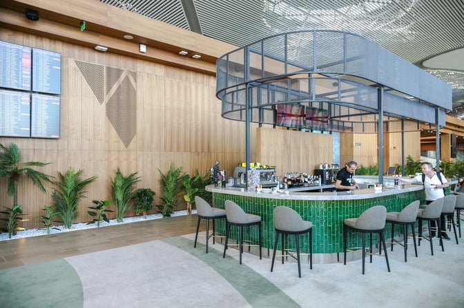 The bar area in the IGA Lounge at Istanbul Airport offers seating and a selection of beverages for travelers.