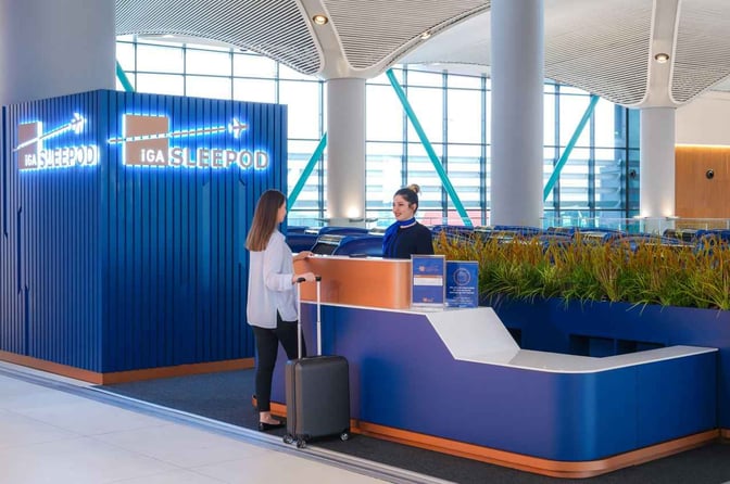 The iGA Sleepod entrance at Istanbul Airport features a reception desk where travelers check in for sleep pod services.