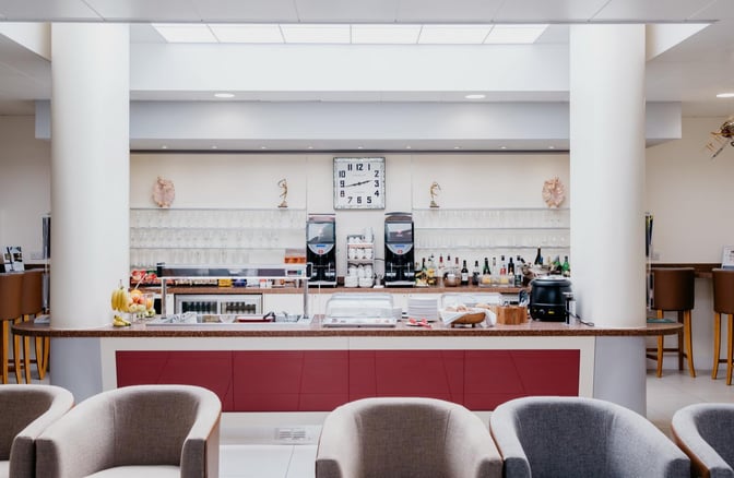 The Executive Lounge at Jersey Airport features a self-serve bar with beverages, snacks, and comfortable seating for travelers.