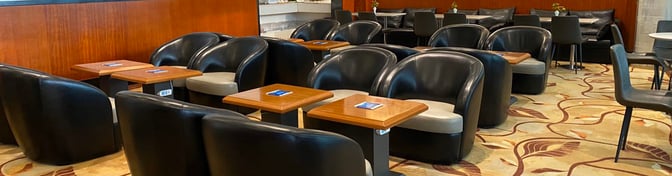 The seating area in China Eastern Lounge at Jinan Yaoqiang International Airport features armchairs and tables for passenger comfort.