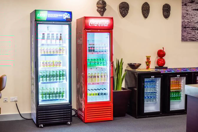 The beverage area at Twiga Lounge features self-serve coolers stocked with assorted drinks, including sodas and bottled water.