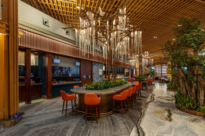The 080 International Lounge at Kempegowda Airport features a central seating area with high chairs and a decorative ceiling installation.