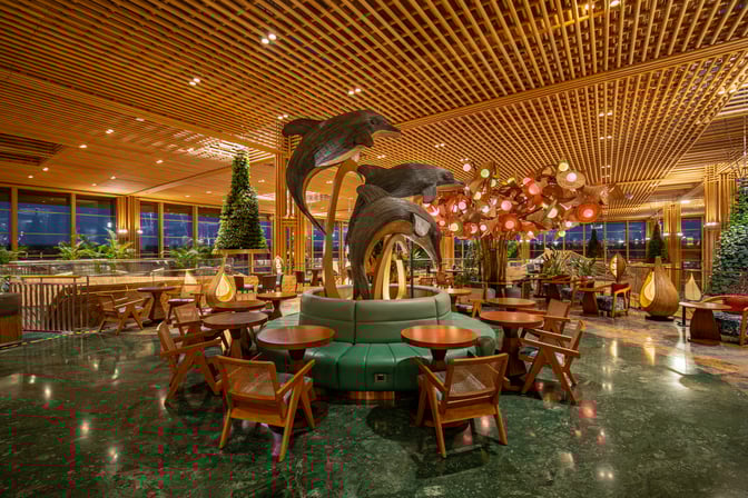 The seating area in the 080 International Lounge at Kempegowda Airport features circular booths and tables with decorative sculptures.