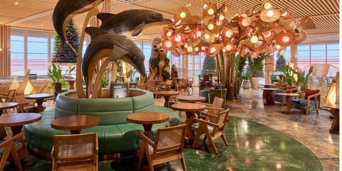 The seating area in the 080 International Lounge at Kempegowda Airport features wooden tables, chairs, and decorative sculptures.