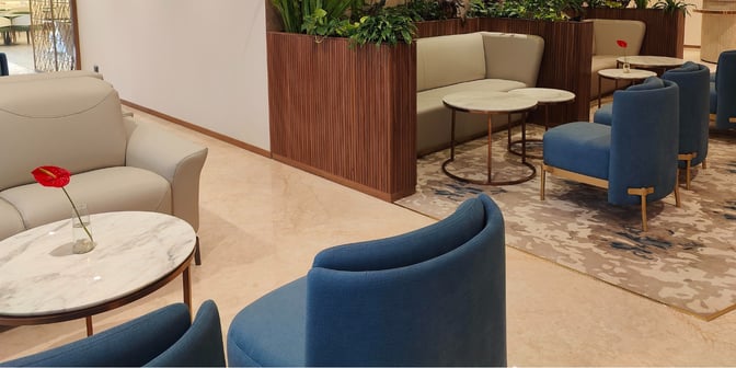 The seating area in the 080 VIP Arrivals Lounge at Kempegowda Airport features comfortable chairs and tables with decorative plants.