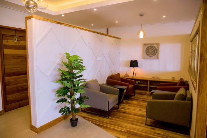 The seating area at Twiga Lounge, Kilimanjaro International Airport, features comfortable armchairs and a side table with a decorative lamp.