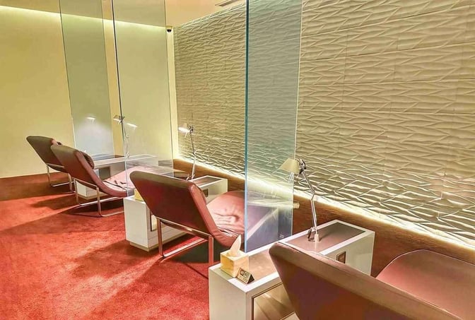 Private seating pods in the Wellcome Lounge at King Fahd International Airport feature individual desks and reading lamps for travelers.